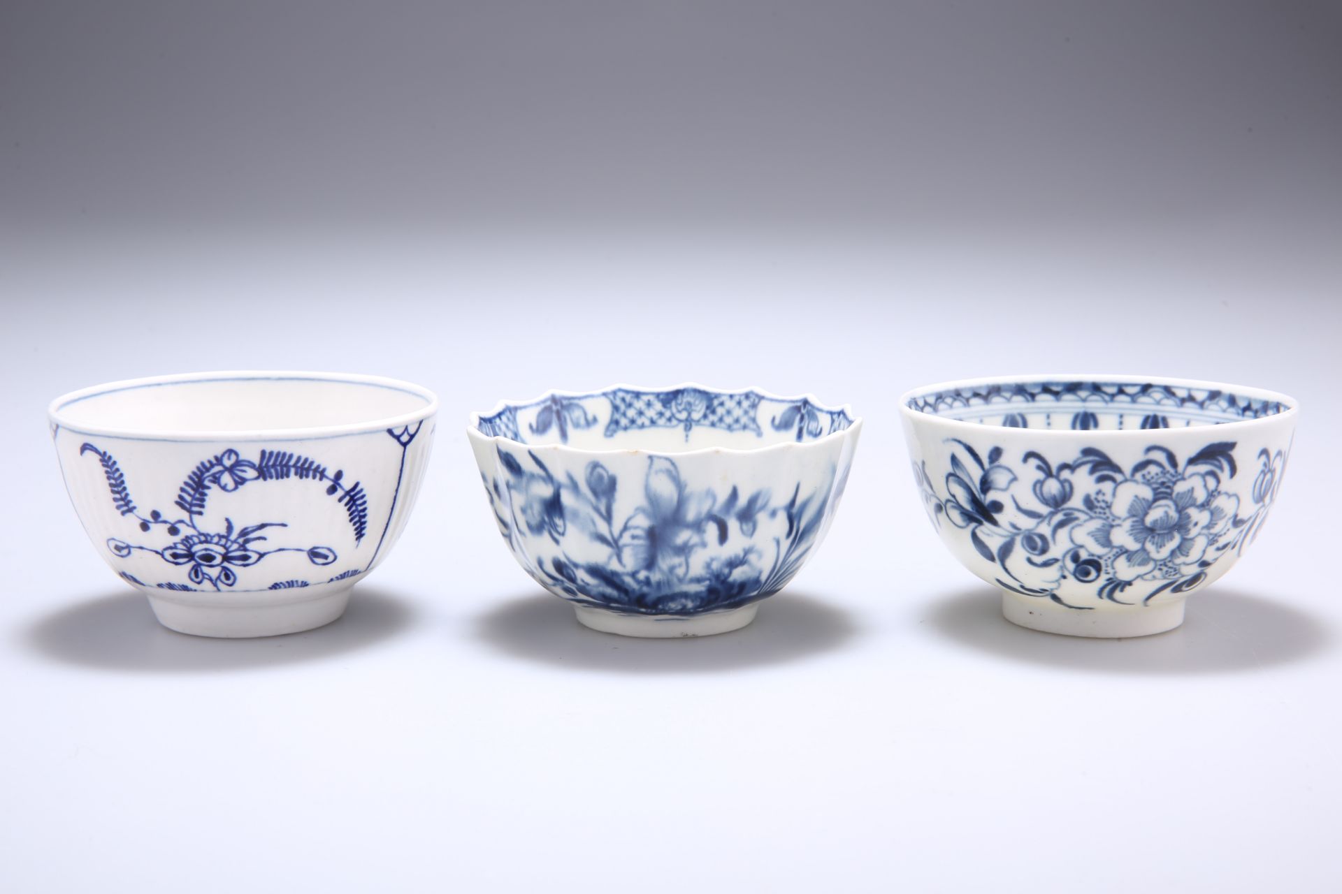 THREE WORCESTER BLUE AND WHITE TEA BOWLS, the first reeded and decorated with the Immortelle