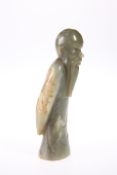 A CHINESE JADE FIGURE, carved as a scholar, standing with arms around his back. 13.5cm high
