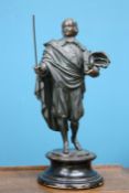 A 19TH CENTURY SPELTER FIGURE, the figure cast standing holding a book and hat, on a turned wooden