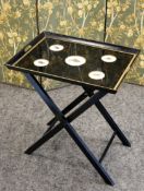 A BLACK AND GILT FOLDING TRAY TABLE, 20TH CENTURY, the rectangular tray with five roundels each with