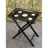 A BLACK AND GILT FOLDING TRAY TABLE, 20TH CENTURY, the rectangular tray with five roundels each with