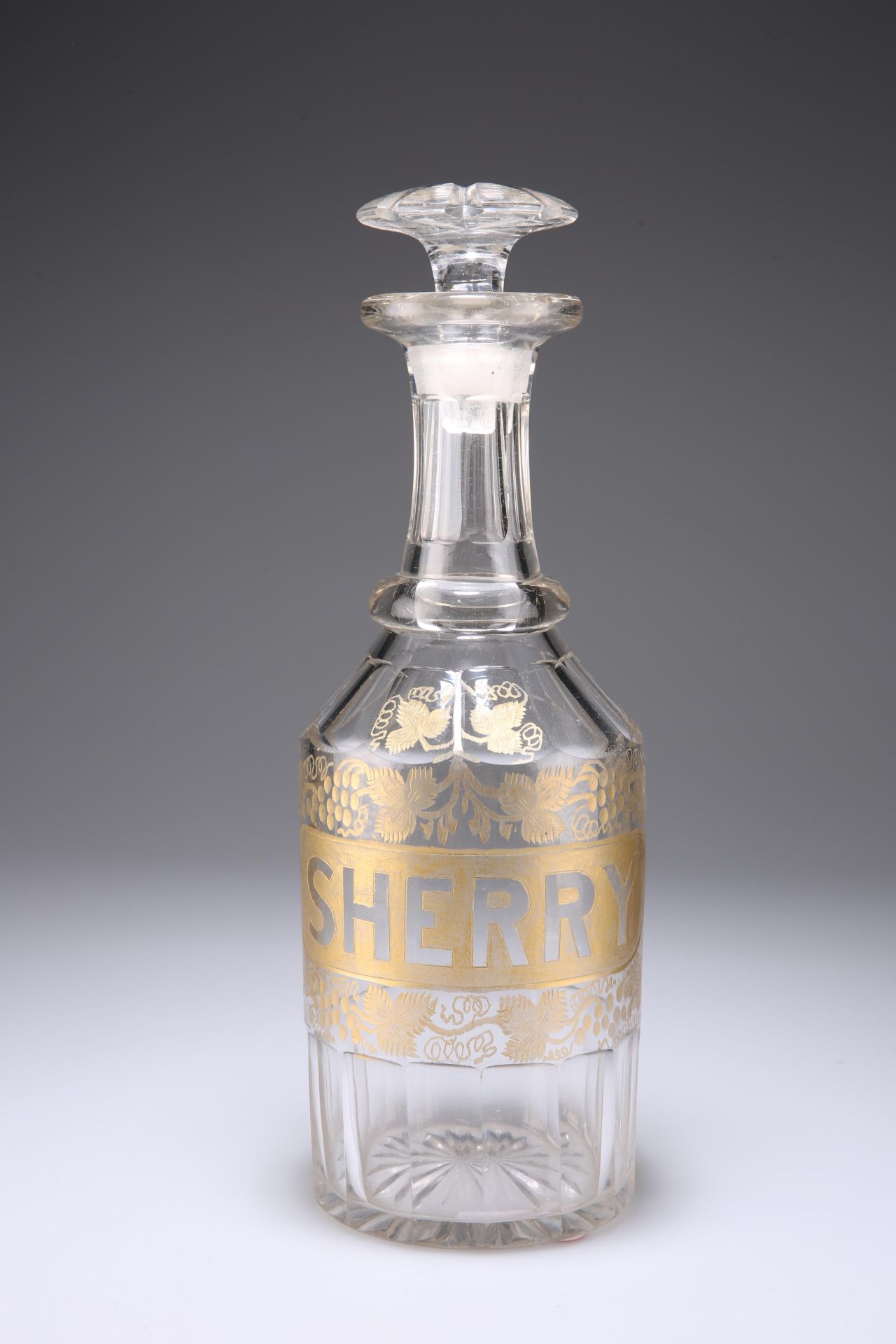 AN EARLY 19TH CENTURY GILDED GLASS SHERRY DECANTER, with facet cut collar around the base and