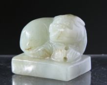 A CHINESE CARVED JADE SEAL, depicting a seated shishi. 3cm by 3cm.