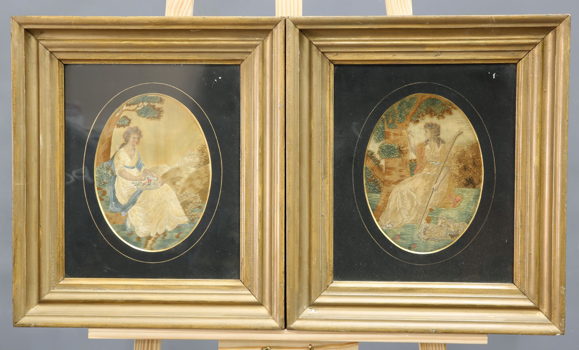 A PAIR OF GEORGE III SILKWORK PICTURES, the first depicting a shepherdess carving the name 'TANCRED'