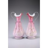 A LARGE PAIR OF VICTORIAN PINK SATIN GLASS EWERS, each of lobed baluster form with clear handle