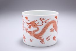 A CHINESE 'DRAGON' BRUSH POT, of squat cylindrical form, iron red painted with two five-claw dragons