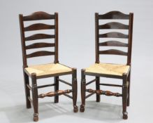 A PAIR OF LANCASHIRE RUSH-SEATED OAK LADDER-BACK SIDE CHAIRS, EARLY 19TH CENTURY, each with five-