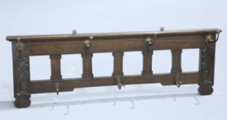 ARTHUR SIMPSON OF KENDAL AN EARLY CARVED OAK WALL-MOUNTED COAT RACK, CIRCA 1900, with carved leaf
