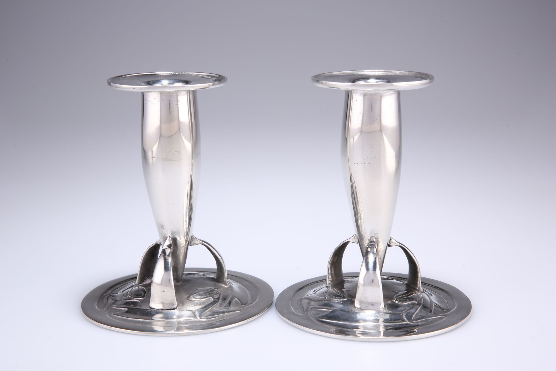 ARCHIBALD KNOX FOR LIBERTY & CO A PAIR OF PEWTER CANDLESTICKS, nos. 0221, each torpedo-shaped stem