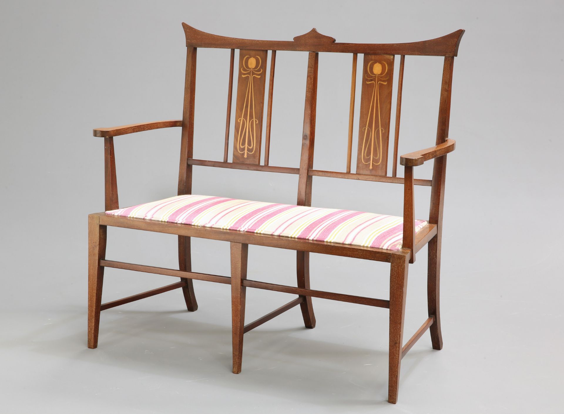 AN ART NOUVEAU INLAID MAHOGANY SETTEE, the back with twin splats inlaid with stylised plantform,