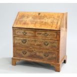 AN EARLY 18TH CENTURY FEATHERBANDED WALNUT SLANT-FRONT BUREAU, with quarter-veneered top and