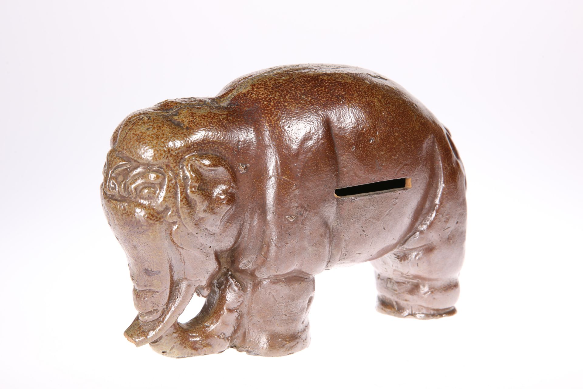 A JAPANESE POTTERY NOVELTY MONEYBOX, MEIJI PERIOD, in the form of an elephant. 15cm high