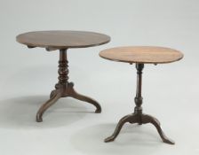 TWO GEORGE III OAK TRIPOD TABLES, each with circular tilt tops and raised on downswept legs (2).