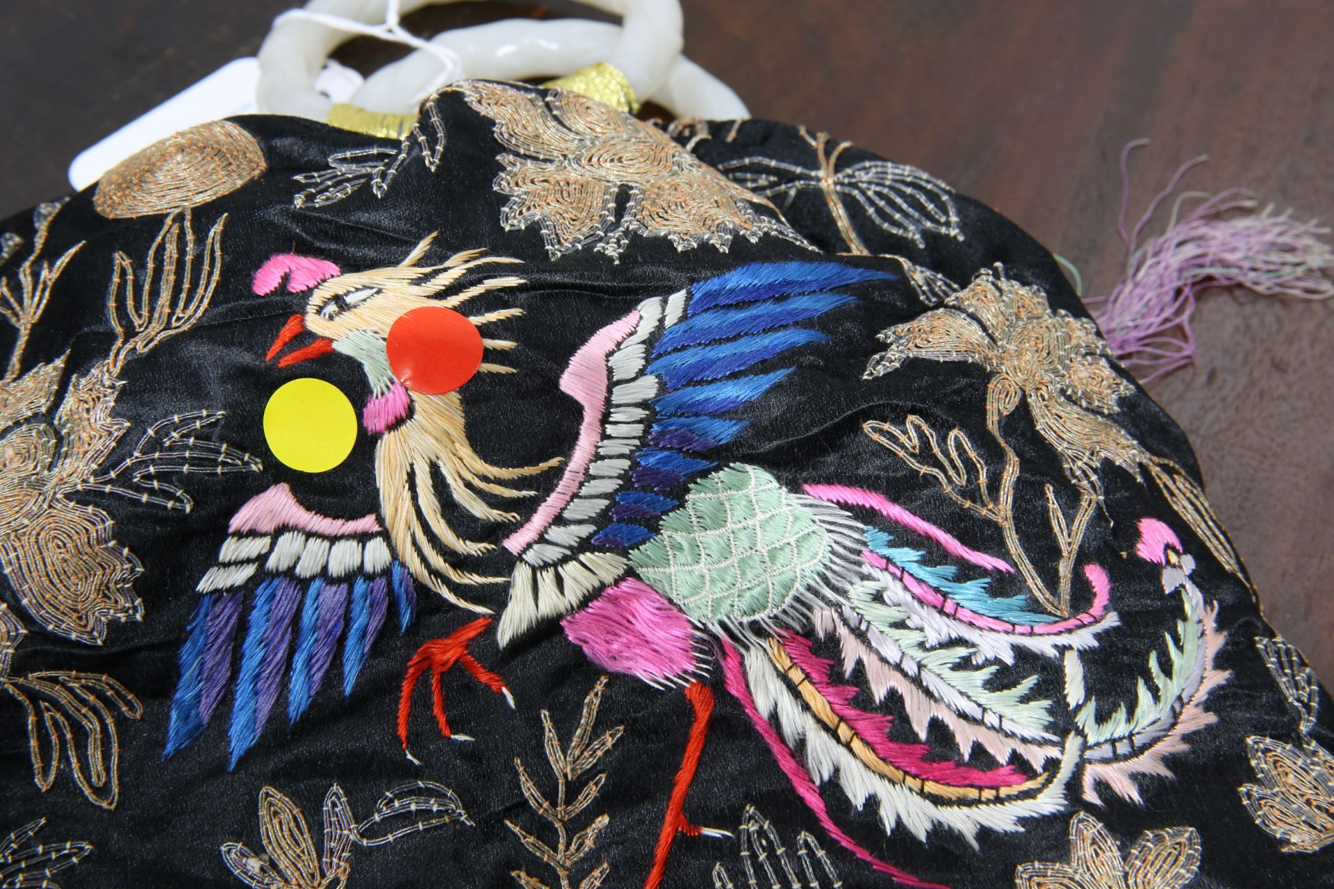 A CHINESE SILK HANDBAG, WITH CARVED JADE HANDLES, embroidered with hoho bird amongst foliage, to the - Bild 3 aus 4