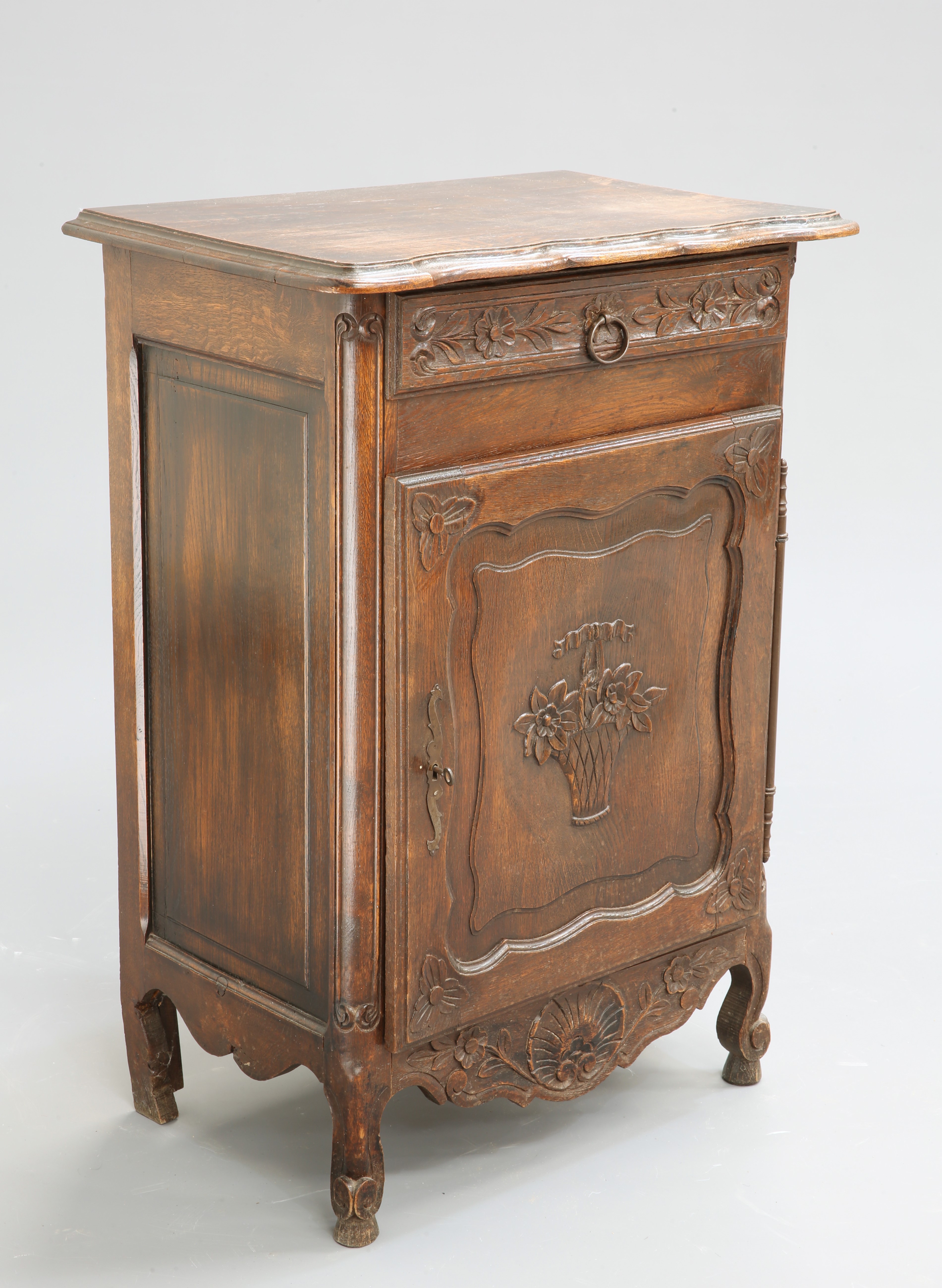 A 19TH CENTURY FRENCH OAK SIDE CABINET, the moulded rectangular top with serpentine front, above a