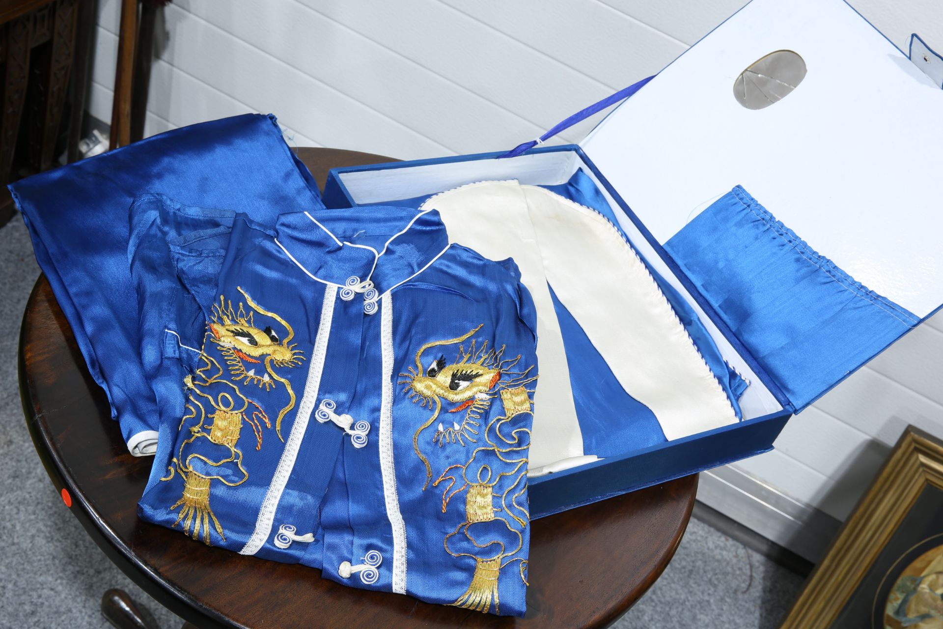 A CHINESE BOXED SET OF BLUE SILK PYJAMAS, GOWN AND SLIPPERS, worked in relief with coloured - Bild 2 aus 2