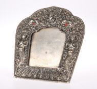 A TIBETAN WHITE-METAL PICTURE FRAME, decorated with figures, easel backed. 11.5cm highThe absence of