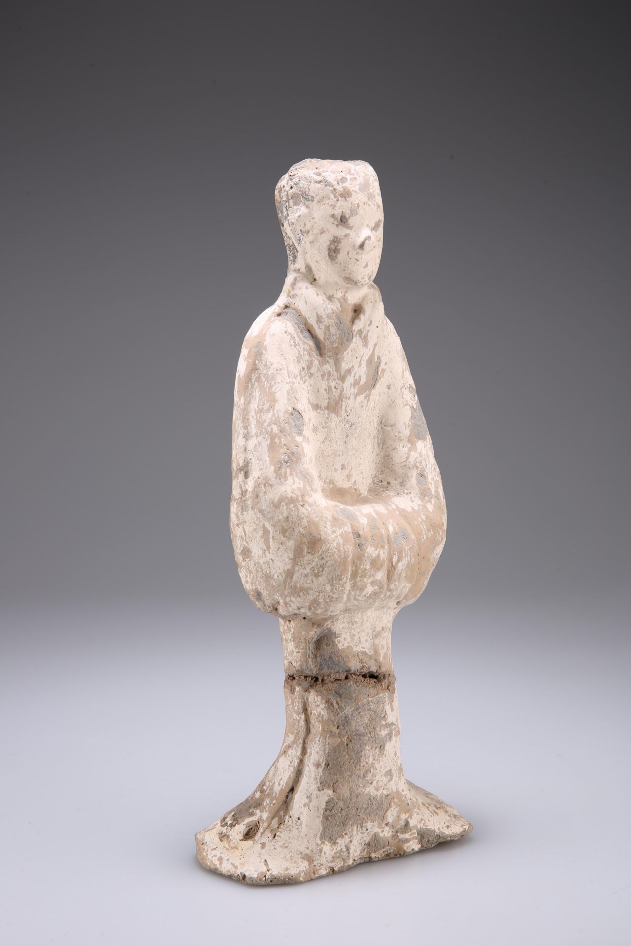 A CHINESE POTTERY TOMB FIGURE, PROBABLY HAN DYNASTY, modelled standing with arms crossed. 30cm high