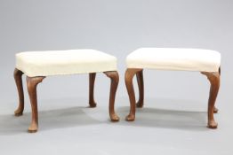~ TWO 18TH CENTURY WALNUT STOOLS, each with rectangular stuffed over seat and cabriole legs. Each