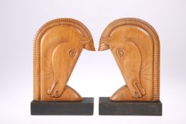A PAIR OF ART DECO STYLE CARVED WOODEN BOOKENDS, each in the form of a stylised horse's head.