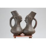 TRIBAL: A PAIR OF CONJOINED 'HEAD' CARVED FLAGONS, probably 19th Century, each carved with