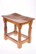 ROBERT THOMPSON OF KILBURN A MOUSEMAN OAK STOOL, the dished rectangular top raised on faceted