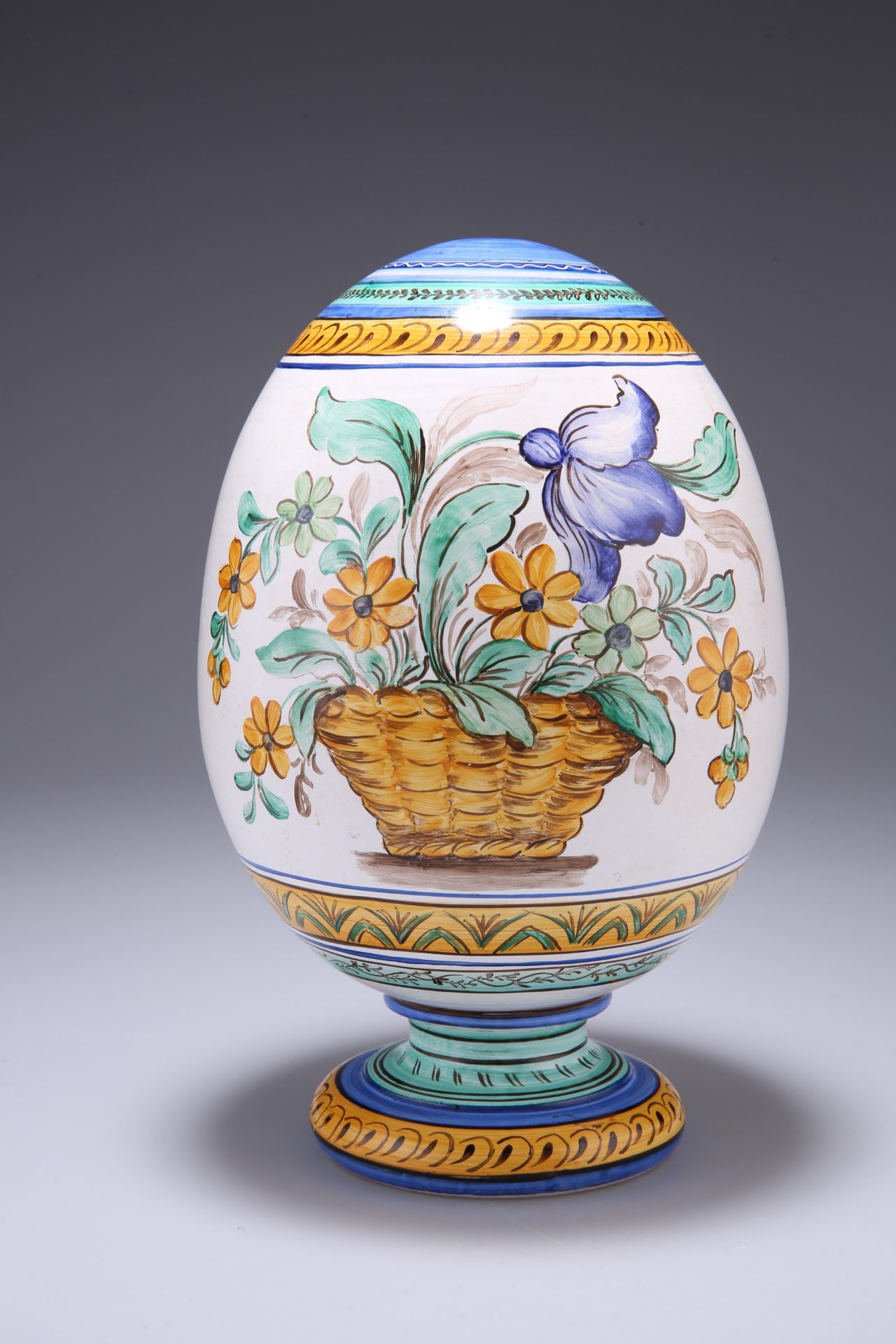 A CONTINENTAL EGG, with integral 'stand', painted with baskets of flowers, signed Milet. 23cm high