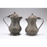 TWO 18TH CENTURY COPPER JUGS AND COVERS, each with hinged domed cover, repousse with scrolling