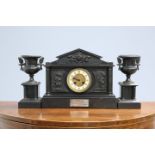 A FRENCH BLACK MARBLE AND PATINATED METAL CLOCK GARNITURE