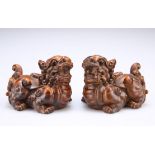 A PAIR OF CHINESE CARVED HARDWOOD FU DOGS, each with bold scroll carving and inset eyes. 5.5cm