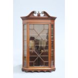 A 19TH CENTURY INLAID MAHOGANY GLAZED HANGING CORNER CABINET, with swan neck pediment centred by a
