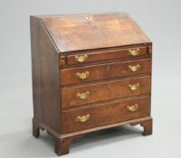 AN 18TH CENTURY OAK SLANT FRONT BUREAU, the hinged slope opening to reveal a fitted interior,