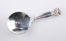 A GEORG JENSEN SILVER CADDY SPOON, c.1930s, stamped Sterling Denmark, the circular bowl with