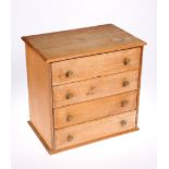 ~ A VICTORIAN PINE MINIATURE CHEST OF DRAWERS, with four drawers and brass pulls. 35cm high, 36.