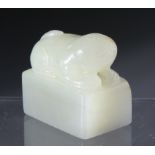 A CHINESE CARVED JADE SEAL, depicting a seated dog. 3cm by 3.5cm.
