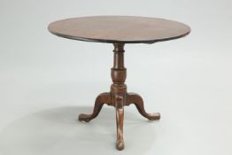 A LARGE GEORGE III OAK TILT-TOP TRIPOD TABLE, the circular top raised on a turned stem continuing to