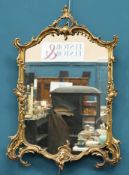 A ROCOCO STYLE GILT-COMPOSITION MIRROR, with acanthus moulded frame. 86.5cm high, 61.5cm wideThe