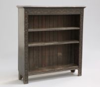 A VICTORIAN CARVED OAK BOOKCASE, the moulded rectangular top over a lunette carved frieze above