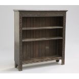 A VICTORIAN CARVED OAK BOOKCASE, the moulded rectangular top over a lunette carved frieze above