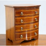 AN EDWARDIAN INLAID MAHOGANY BOW-FRONT MINIATURE CHEST OF DRAWERS, fitted with four graduated