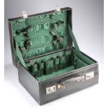 AN EDWARDIAN LEATHER TRAVELLING VANITY CASE, with green silk lined interior. 45.5cm wide