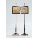 A PAIR OF VICTORIAN ROSEWOOD POLE SCREENS, each with floral needlework banner and brass hairy paw