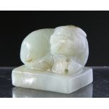 A CHINESE CARVED JADE SEAL, depicting a seated shishi. 3cm by 3cm.