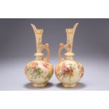 A PAIR OF ROYAL WORCESTER BLUSH IVORY EWERS, each with tapering neck and globular body, painted with