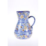 A SPANISH FAIENCE JUG, 19TH CENTURY, with strap handle. 19.5cm