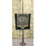 A VICTORIAN BEADWORK POLE SCREEN, the floral banner suspending from a turned brass rail, raised on a