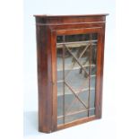 A GEORGE III MAHOGANY GLAZED HANGING CORNER CABINET,  with astragal glazed door enclosing shaped