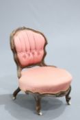 A VICTORIAN WALNUT AND UPHOLSTERED NURSING CHAIR, the cartouche-shaped back with buttoned