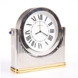 A CARTIER BI-COLOURED METAL DESK CLOCK, the reeded case with applied blue cabochons to the shoulders