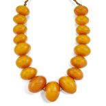 A LARGE COMPOSITE AMBER BEAD NECKLACE OR PRAYER BEADS, comprising a single strand of seventeen
